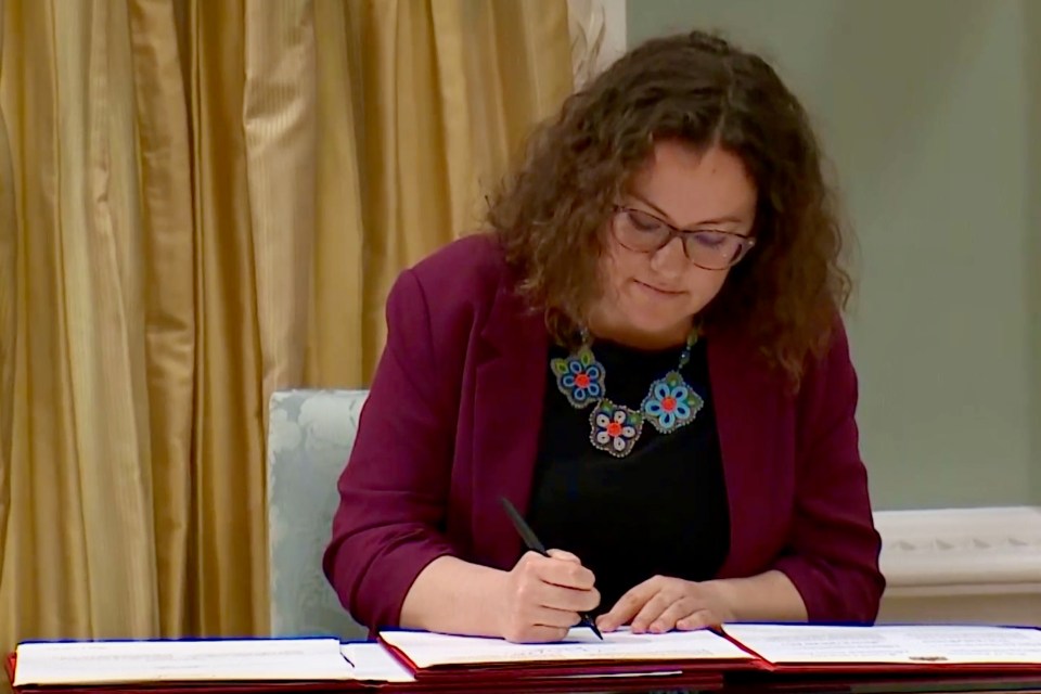 Alty finishes her part of the ceremony with a signature. Image: CPAC